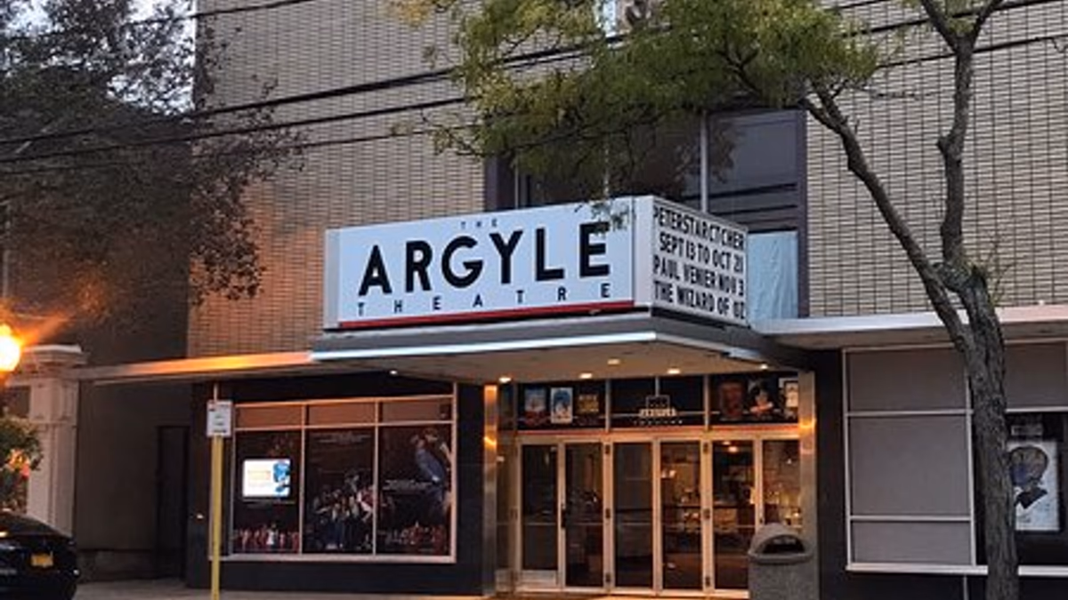 Cabaret stage at the Argyle Theater with a singer at a microphone and table seating in the foreground